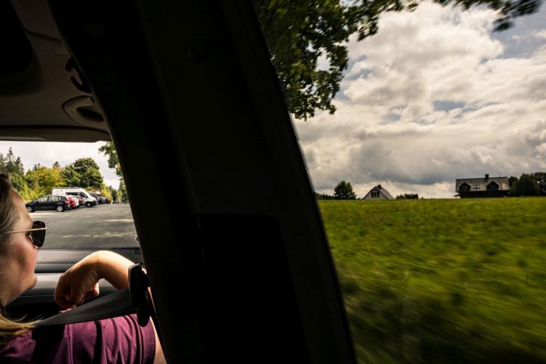 Blick aus dem Autofenster Auf dem Beifahrersitz schaut eine Frau in die Ferne Landschaft.
